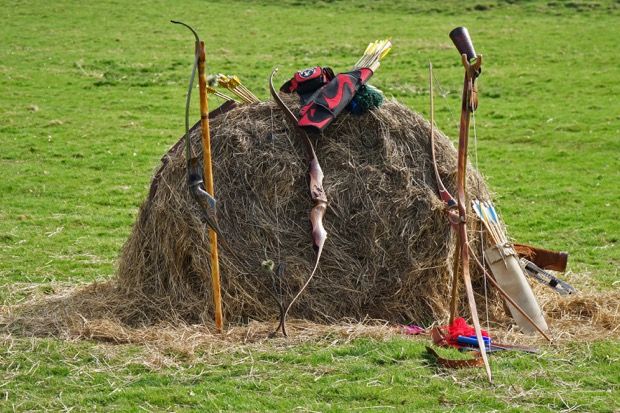 [bows stacked on hay bail]