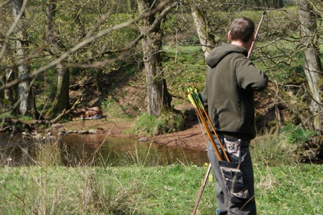 [archer shooting deer target over river]